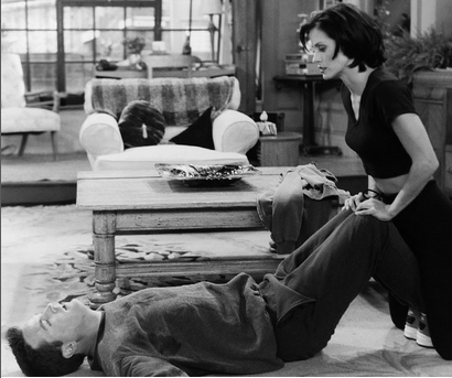 Monica et Chandler font des exercices sportifs. Monica porte un cropped top. 