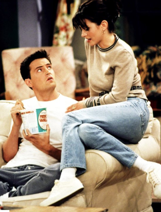Monica est assise avec Chandler sur le canapé de son appartement. Elle porte une nouvelle fois, des baskets blanches.